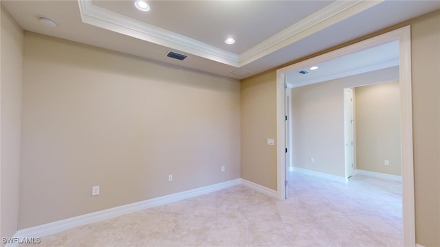 empty room featuring crown molding and a tray ceiling