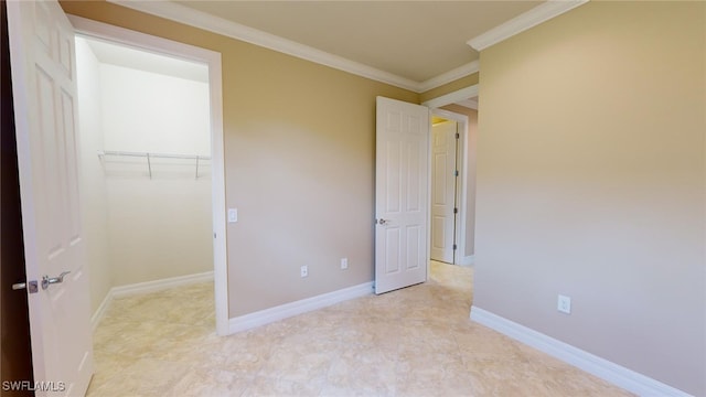 unfurnished bedroom with a spacious closet, a closet, and ornamental molding