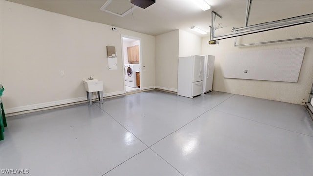 garage with washer and dryer, white fridge, sink, and a garage door opener