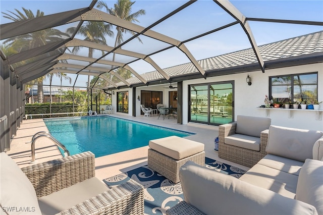 view of pool featuring outdoor lounge area, a patio, ceiling fan, and a lanai