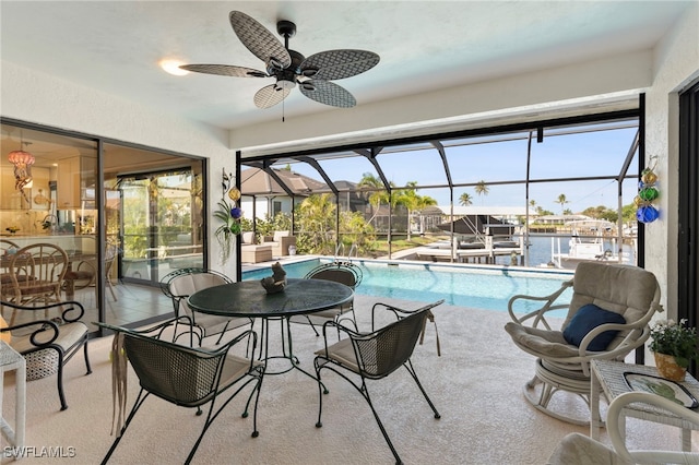 sunroom / solarium featuring ceiling fan, a water view, and a swimming pool