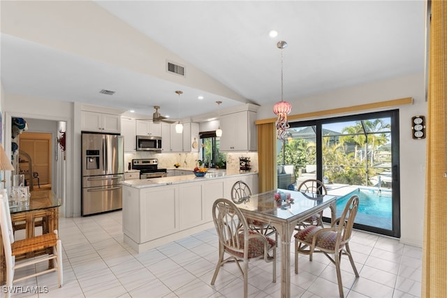 tiled dining room featuring vaulted ceiling