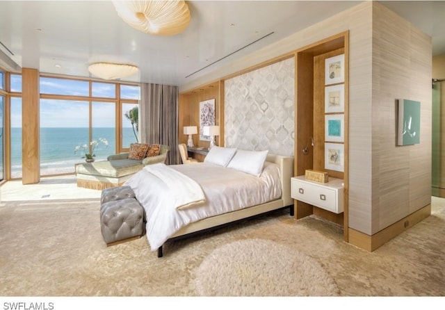 carpeted bedroom with floor to ceiling windows and a water view