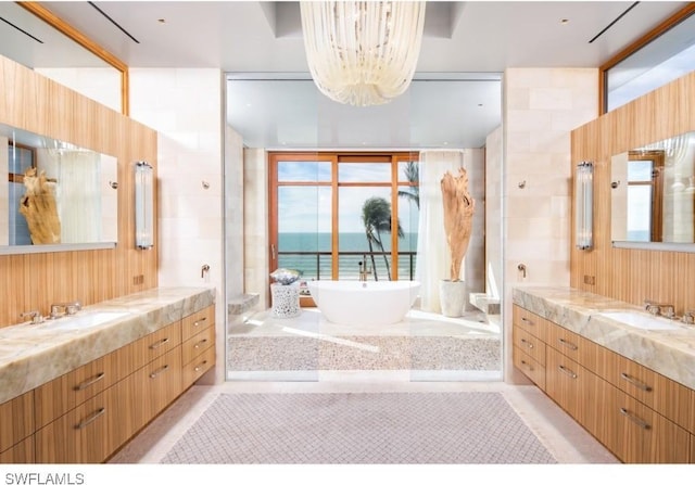 bathroom with vanity, a water view, tile walls, and a bathing tub