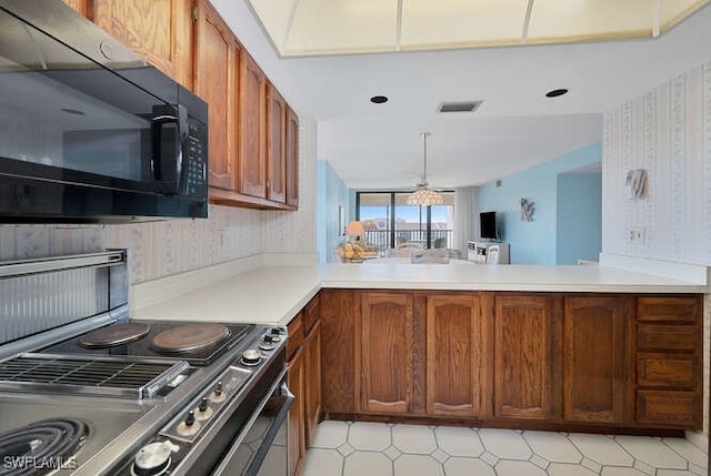 kitchen featuring kitchen peninsula, pendant lighting, and stainless steel stove