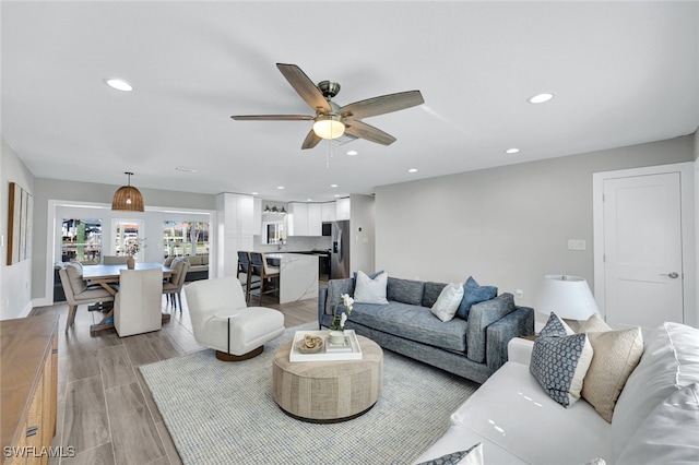 living room with light wood-type flooring and ceiling fan