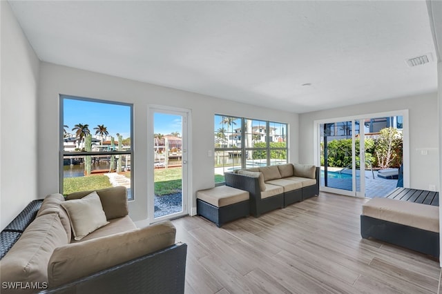 living room featuring light hardwood / wood-style flooring and a water view