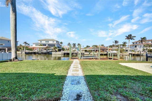 view of dock with a lawn and a water view