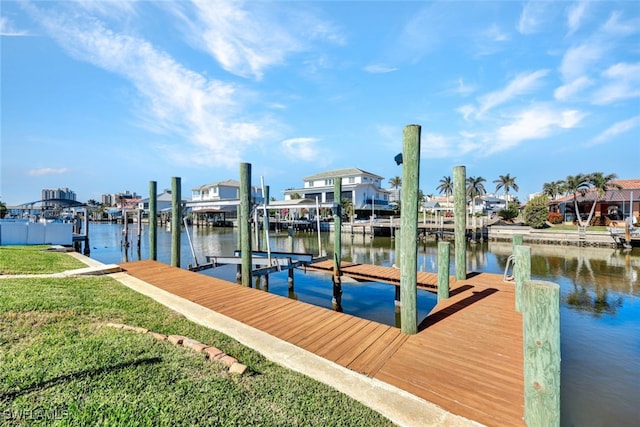 dock area with a water view and a lawn