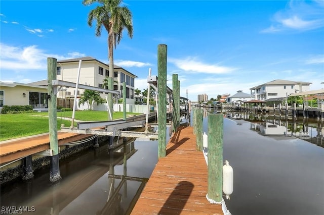 dock area featuring a lawn and a water view