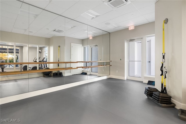 exercise area with a healthy amount of sunlight and a drop ceiling