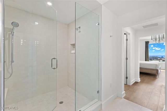 bathroom featuring wood-type flooring and a shower with shower door