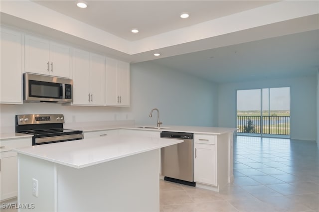 kitchen with white cabinetry, sink, a center island, kitchen peninsula, and appliances with stainless steel finishes