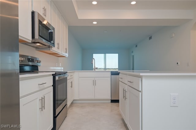 kitchen featuring white cabinets, appliances with stainless steel finishes, kitchen peninsula, and sink