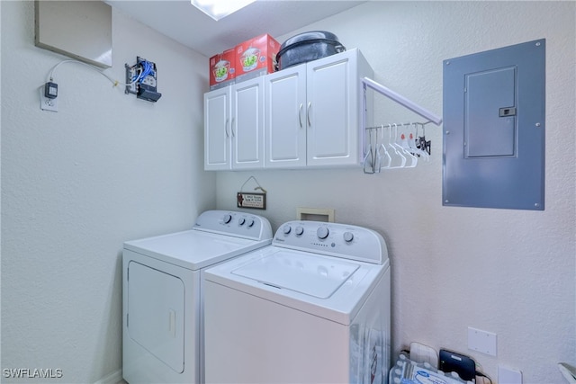 washroom with electric panel, cabinets, and independent washer and dryer