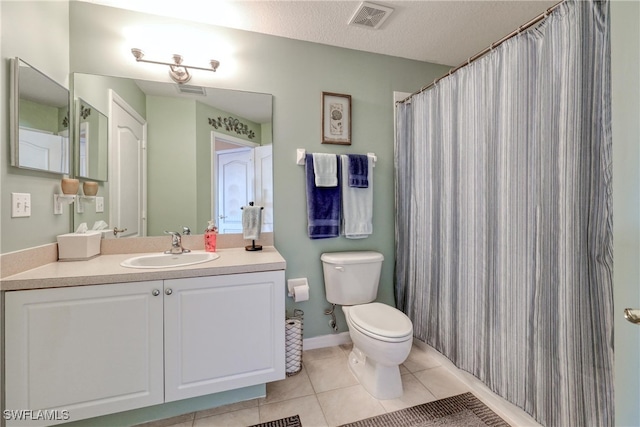 bathroom featuring tile patterned flooring, vanity, toilet, and a textured ceiling