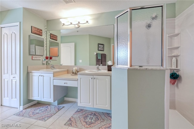 bathroom featuring tile patterned floors, vanity, walk in shower, and a textured ceiling