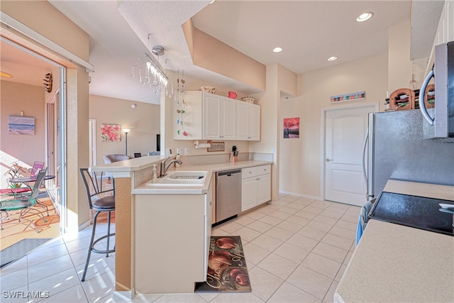 kitchen featuring a kitchen bar, kitchen peninsula, stainless steel appliances, sink, and light tile patterned floors