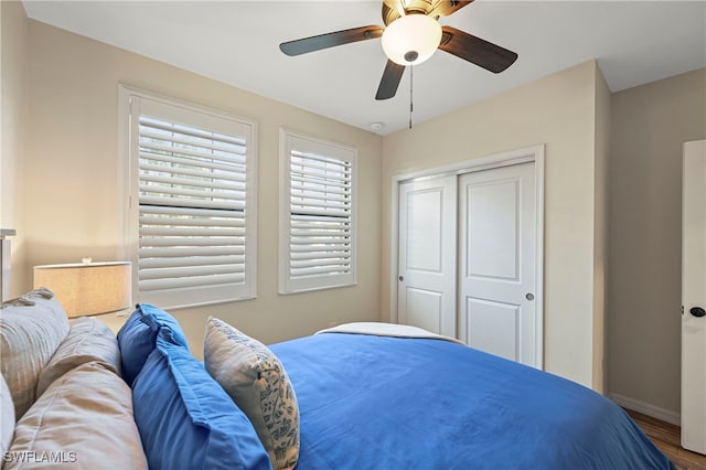 bedroom with hardwood / wood-style floors, ceiling fan, and a closet