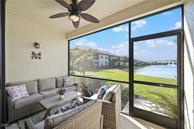 sunroom / solarium with ceiling fan and a water view