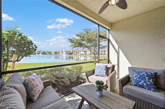 sunroom / solarium with a water view and ceiling fan