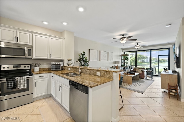 kitchen featuring white cabinets, sink, kitchen peninsula, and stainless steel appliances