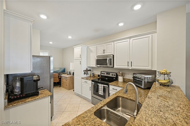 kitchen with light stone counters, sink, white cabinets, and appliances with stainless steel finishes