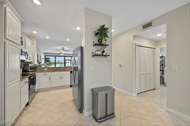 kitchen featuring white cabinetry, sink, light tile patterned floors, and stainless steel appliances