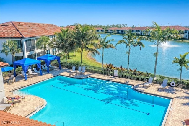 view of swimming pool featuring a water view and a patio area