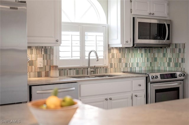 kitchen featuring a healthy amount of sunlight, white cabinetry, sink, and appliances with stainless steel finishes