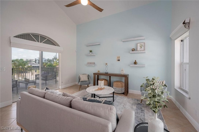 tiled living room featuring ceiling fan and high vaulted ceiling