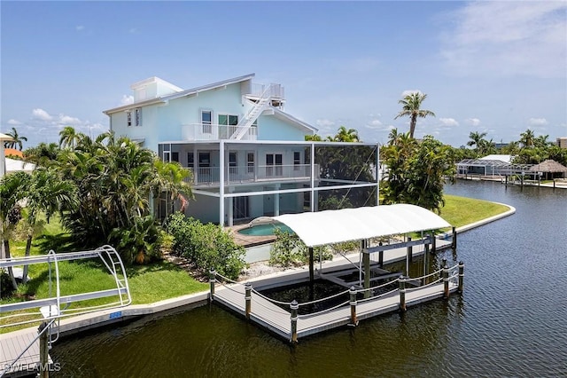 back of property with glass enclosure, a balcony, and a water view