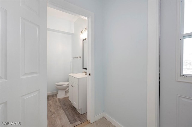 bathroom with toilet, vanity, and hardwood / wood-style flooring