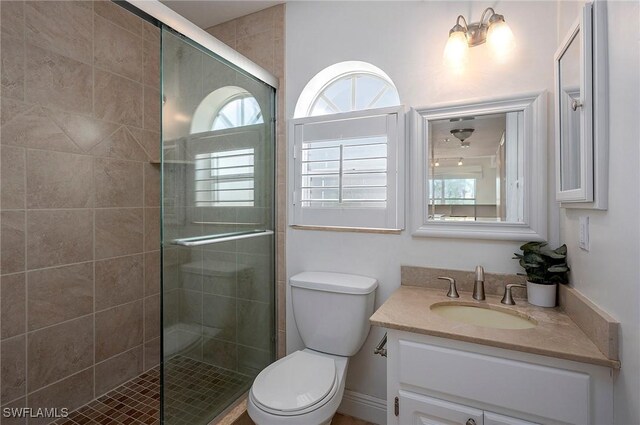 bathroom featuring vanity, toilet, and walk in shower