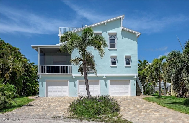 coastal inspired home with a balcony and a garage