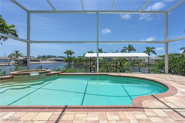 view of pool with a lanai, an in ground hot tub, and a water view