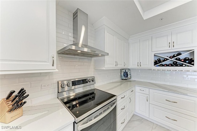 kitchen with wall chimney exhaust hood, white cabinetry, light stone counters, and electric stove