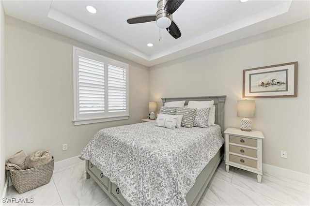 bedroom with a raised ceiling and ceiling fan