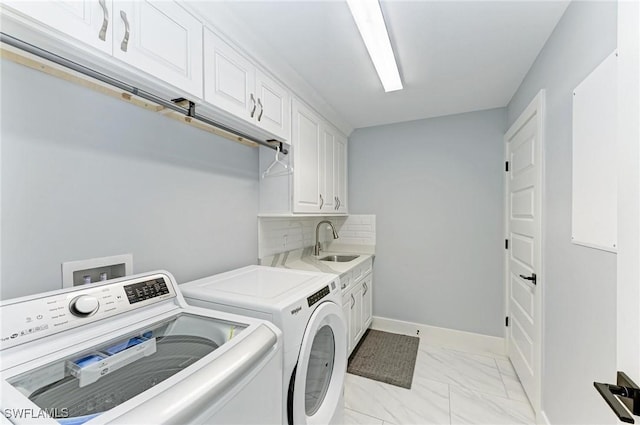 washroom with washing machine and clothes dryer, cabinets, and sink