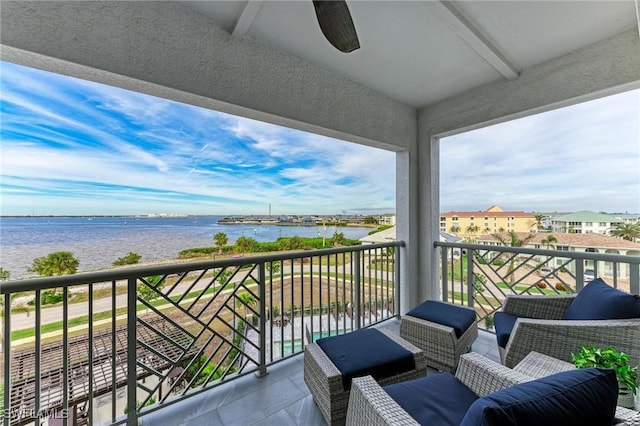 balcony with ceiling fan and a water view