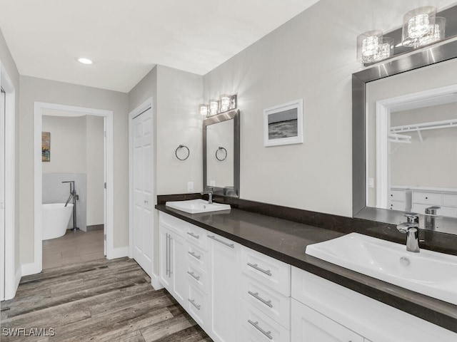 bathroom with a bathing tub, vanity, and hardwood / wood-style flooring