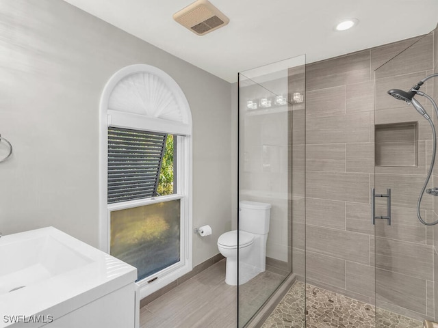 bathroom featuring vanity, toilet, and an enclosed shower