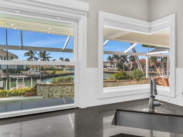 entryway with a healthy amount of sunlight, a water view, and sink