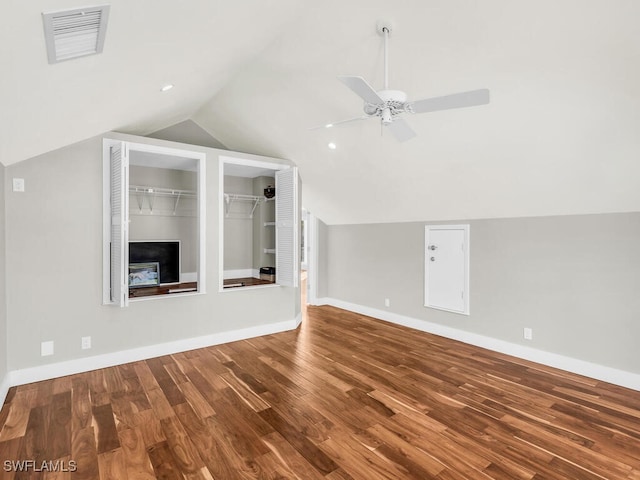 additional living space featuring ceiling fan, a fireplace, lofted ceiling, and hardwood / wood-style flooring