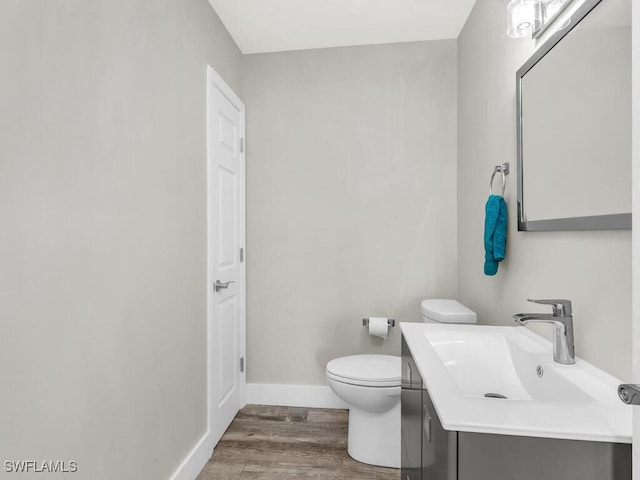 bathroom with vanity, hardwood / wood-style flooring, and toilet