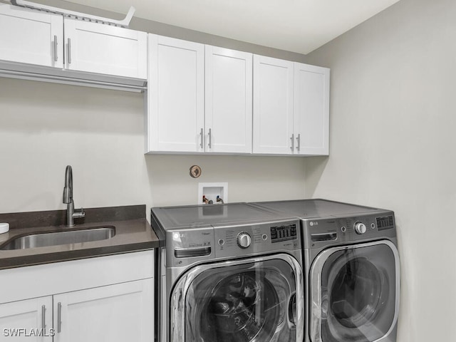 laundry area with washer and dryer, cabinets, and sink