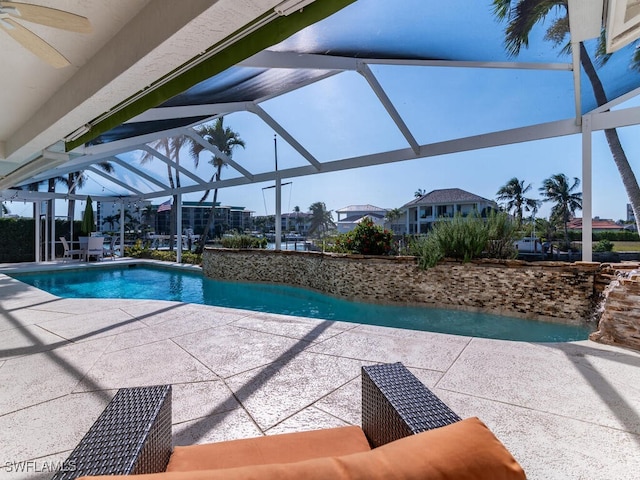 view of swimming pool with a lanai, ceiling fan, and a patio