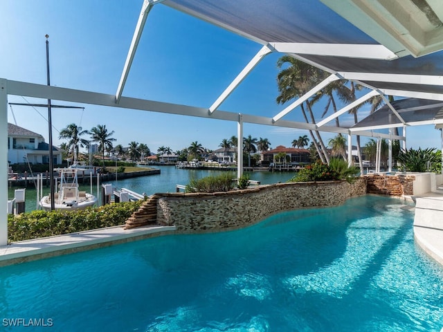 view of swimming pool featuring glass enclosure and a water view