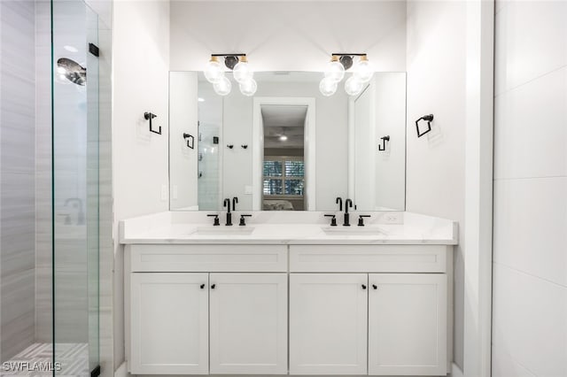 bathroom with a shower with shower door and vanity