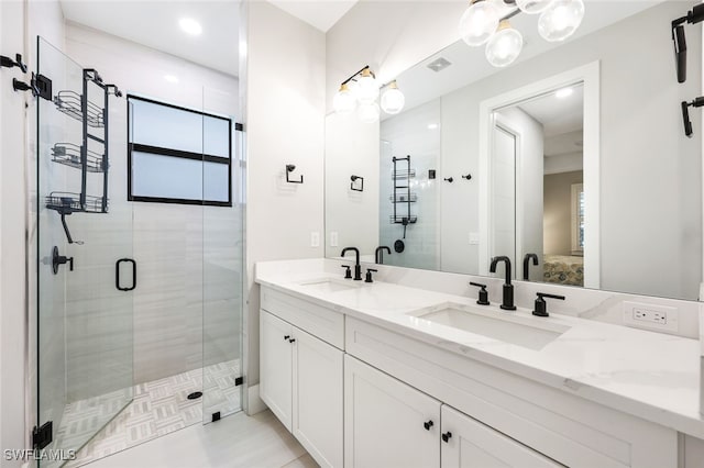 bathroom featuring a shower with door and vanity